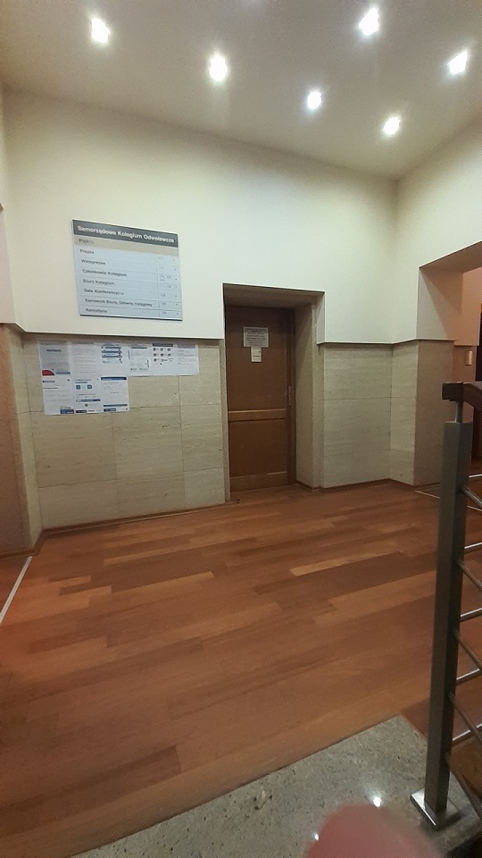 Na zdjęciu widok ze schodów na pierwszym piętrze, widoczne drzwi numer 100, pokój Kancelarii.